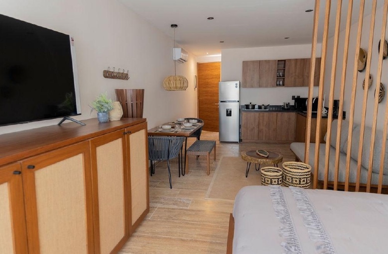 Interior of unit 109 at Erena Mindful Apartments, showing the open studio layout with bed, kitchenette and dining table