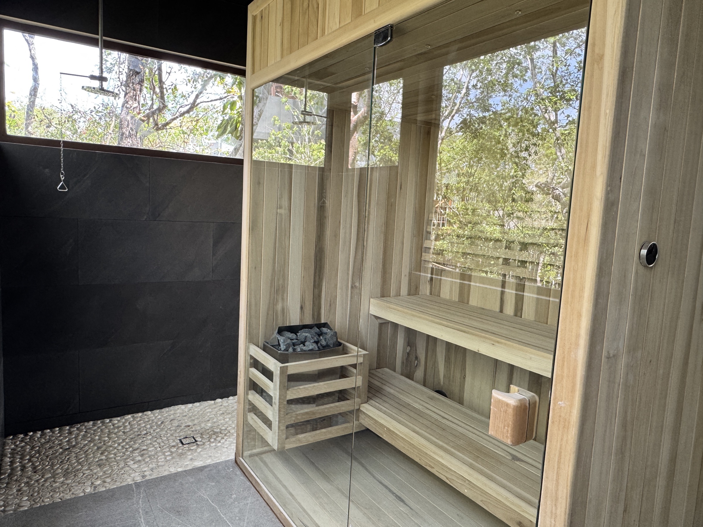 Wood-panelled sauna with a jungle-facing window at Siwá Élevé