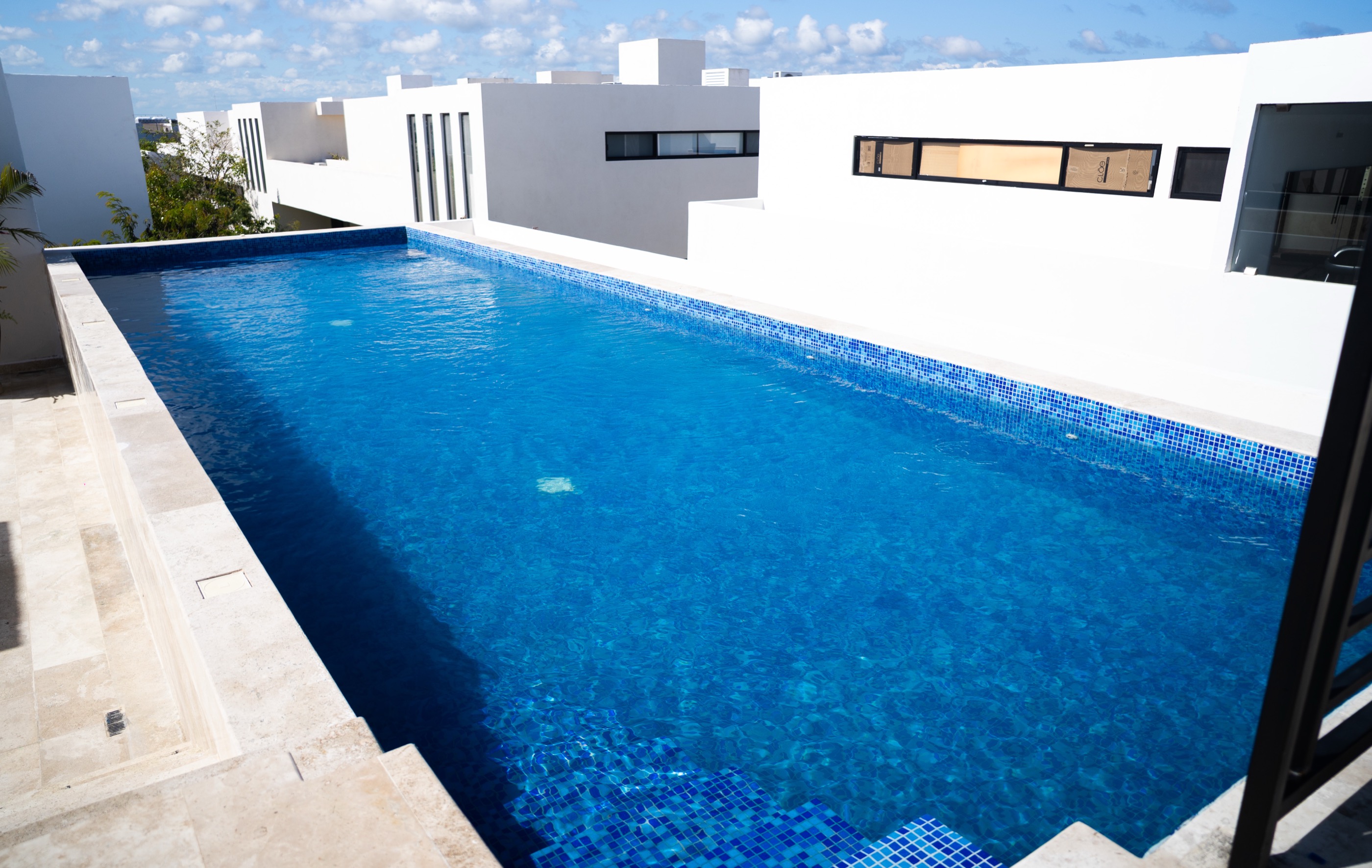 Rooftop lap pool and deck at Town Center Zamá
