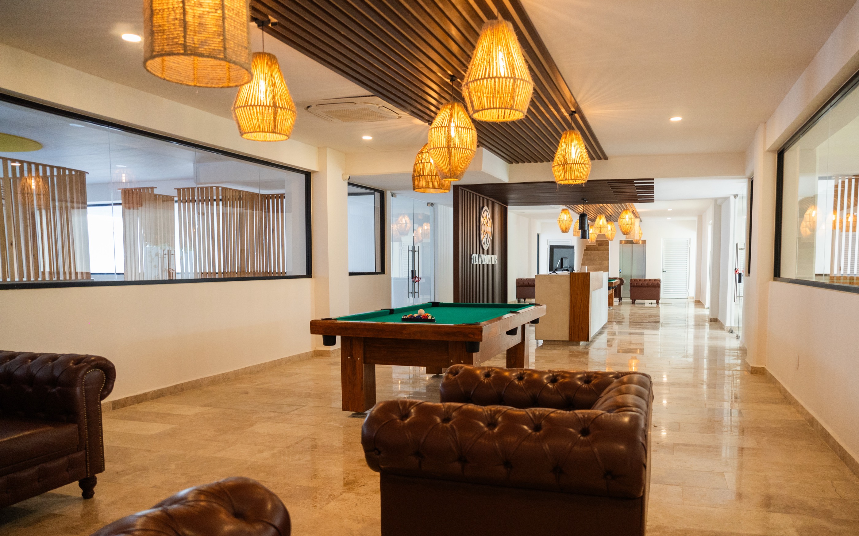 Social lounge with pool table and leather sofas at Town Center Zamá