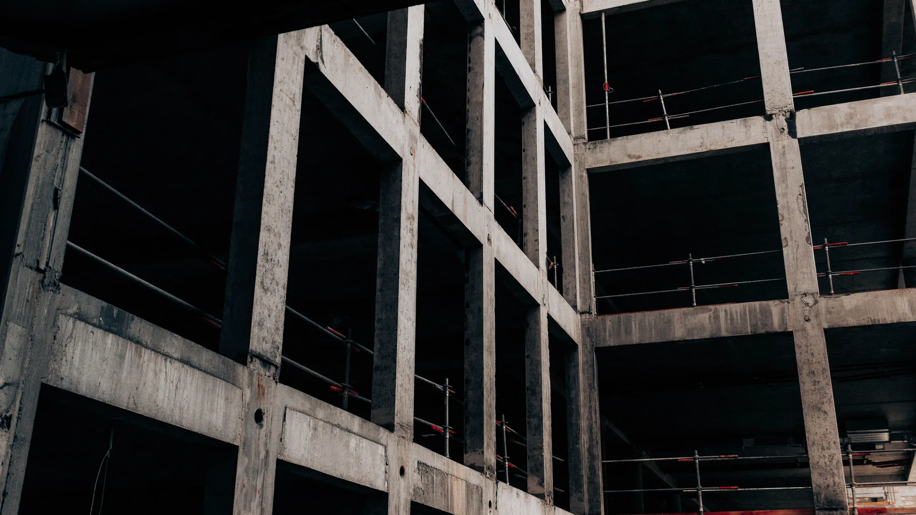 Low-angle view of an unfinished concrete frame with bare beams and open floors